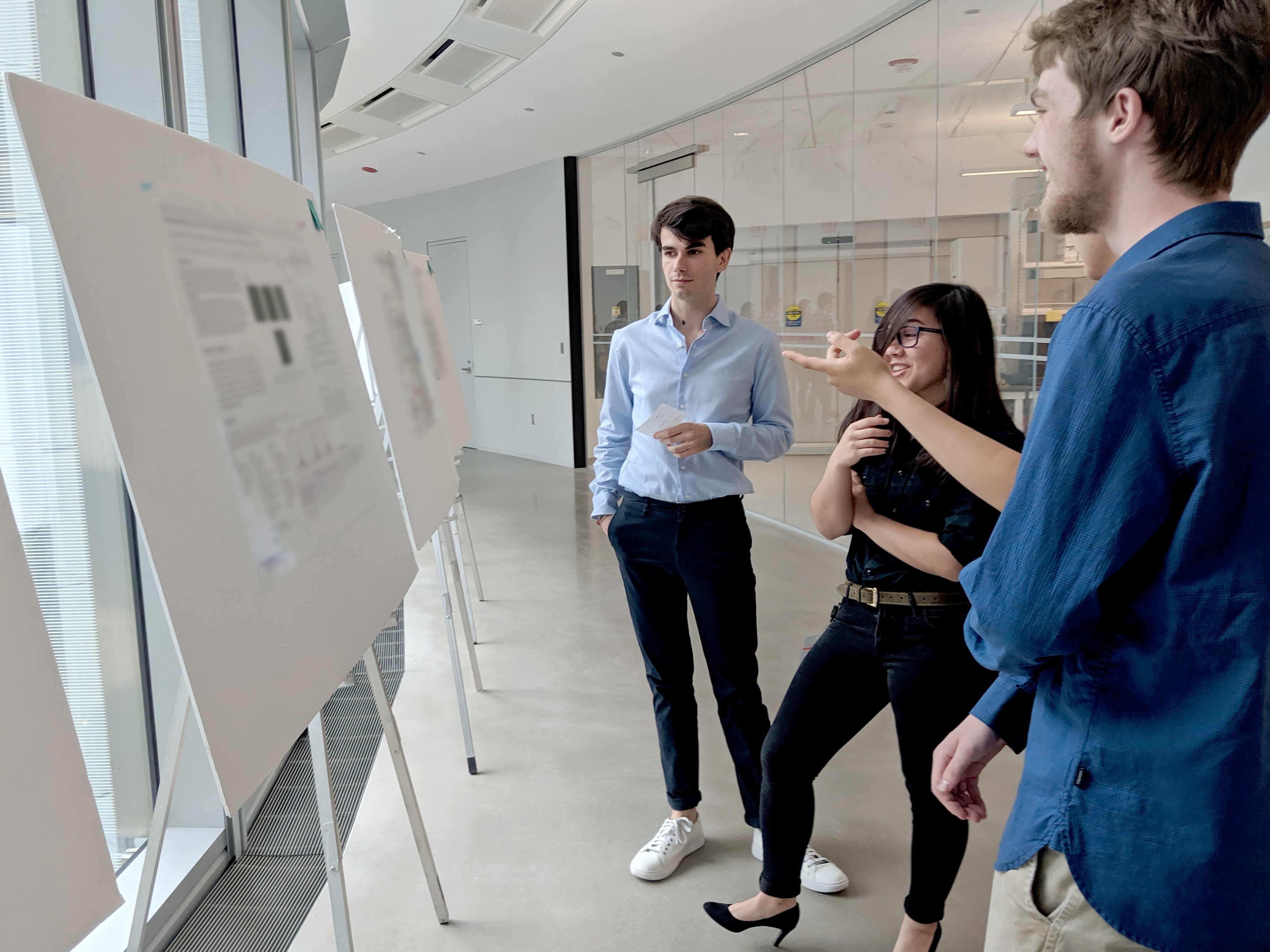 An intern presents his poster at the Summer Research Symposium